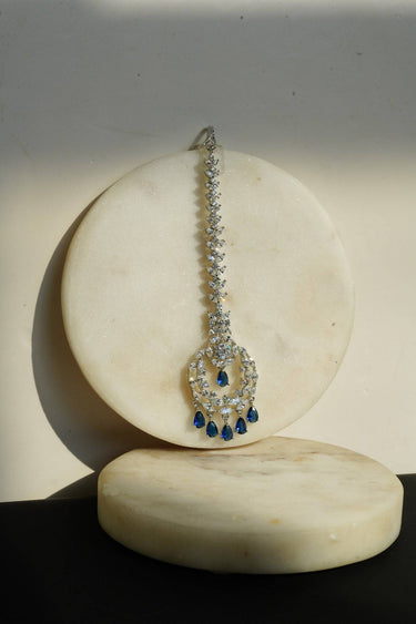 Farida Rhodium Dainty Chand AD Maang Tikka displayed on marble