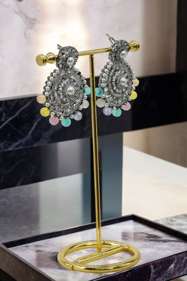 Side view of Navya Black Plated Chandbali Earrings with detailed craftsmanship and colorful beads, displayed on a gold stand.