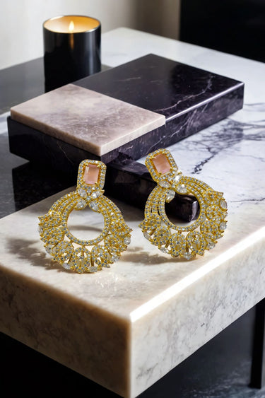 The Mia - Dainty Chandbali Earrings with CZ Stones in gold and blush pink, displayed on a marble surface for a luxurious jewelry look.