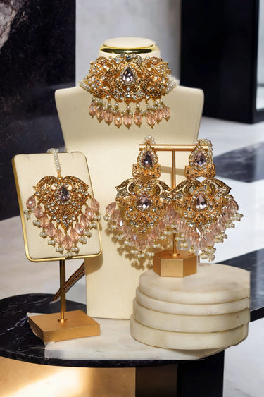 Gold Noreen Choker Necklace Set - Elegant Pakistani Bridal Jewels with pink teardrop stones and pearl accents, displayed on bust and stand.