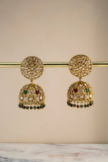 Antique gold jhumka earrings with intricate Nakshi carving, American diamond embellishments, and hanging pearl beads for festive occasions