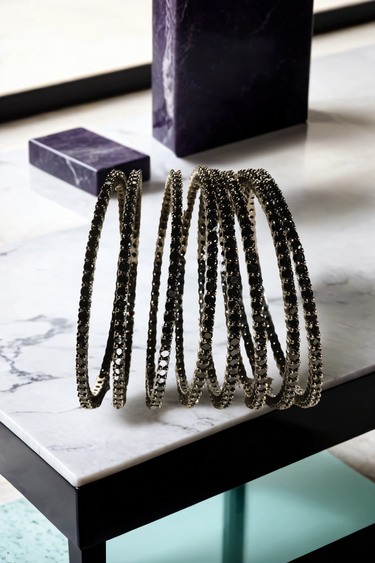 Simran Bangles - Set of 8 Choori Style Black Plated Bangles with Black Stones by Inaury, displayed on a marble surface with luxurious black detailing.