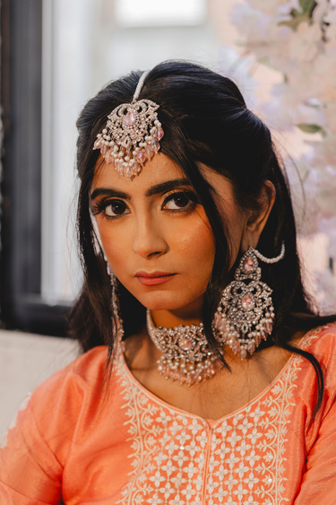 Close-up of model in Noreen Choker Necklace Set - Elegant Pakistani Bridal Jewels, showcasing tikka and earrings with pink teardrop stones.