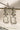 Side view of Aayat Statement Earrings in crystal white showcasing intricate floral design and sparkling pavé halo. Rhodium-plated dangle earrings.
