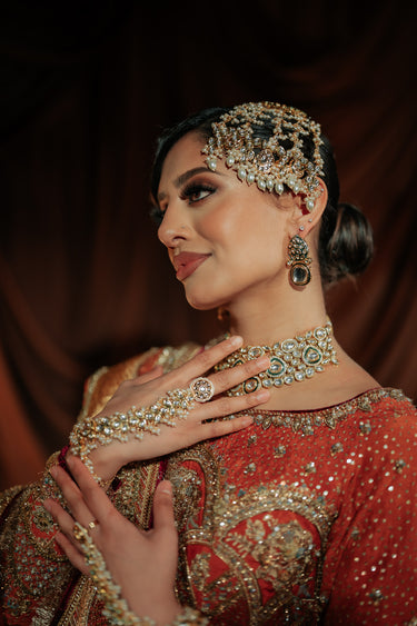 Woman in traditional attire with jewelry against a dark background