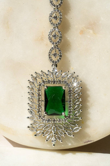 Close-up of Alora Maang Tikka featuring a faceted green stone surrounded by marquise-cut AD stones in rhodium plating.