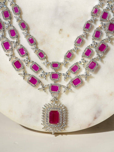 Amisha Triple Layer Diamante Accent AD Necklace Set in gold or rhodium-plated silver finish with color options of silver & sapphire blue, silver & green, gold & green, and silver & ruby, featuring floral and cushion cut stone patterns with matching earrings.