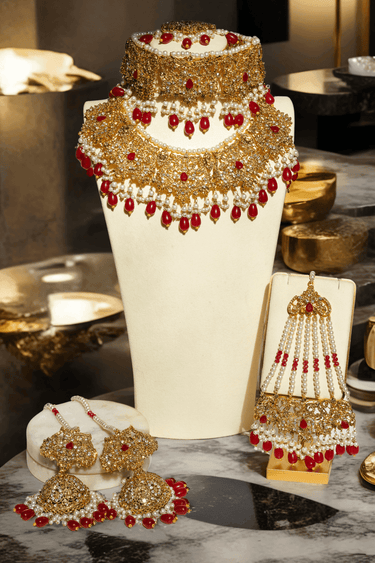 Amreen Gold Plated Red Bridal Set - 5-piece jewelry set with gold plating, white and golden zircon stones, faux pearls, and red beads.