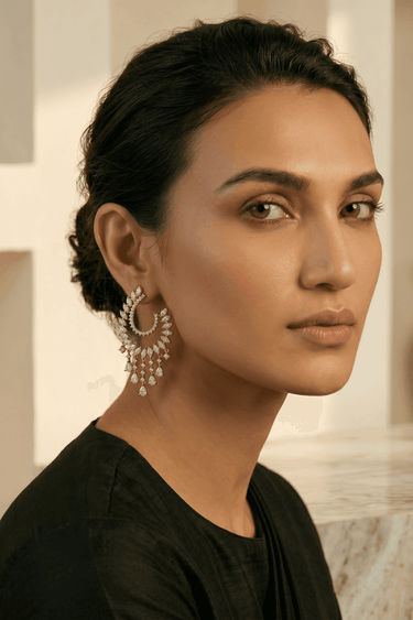 Woman wearing ornate Indian AD earrings with a neutral background