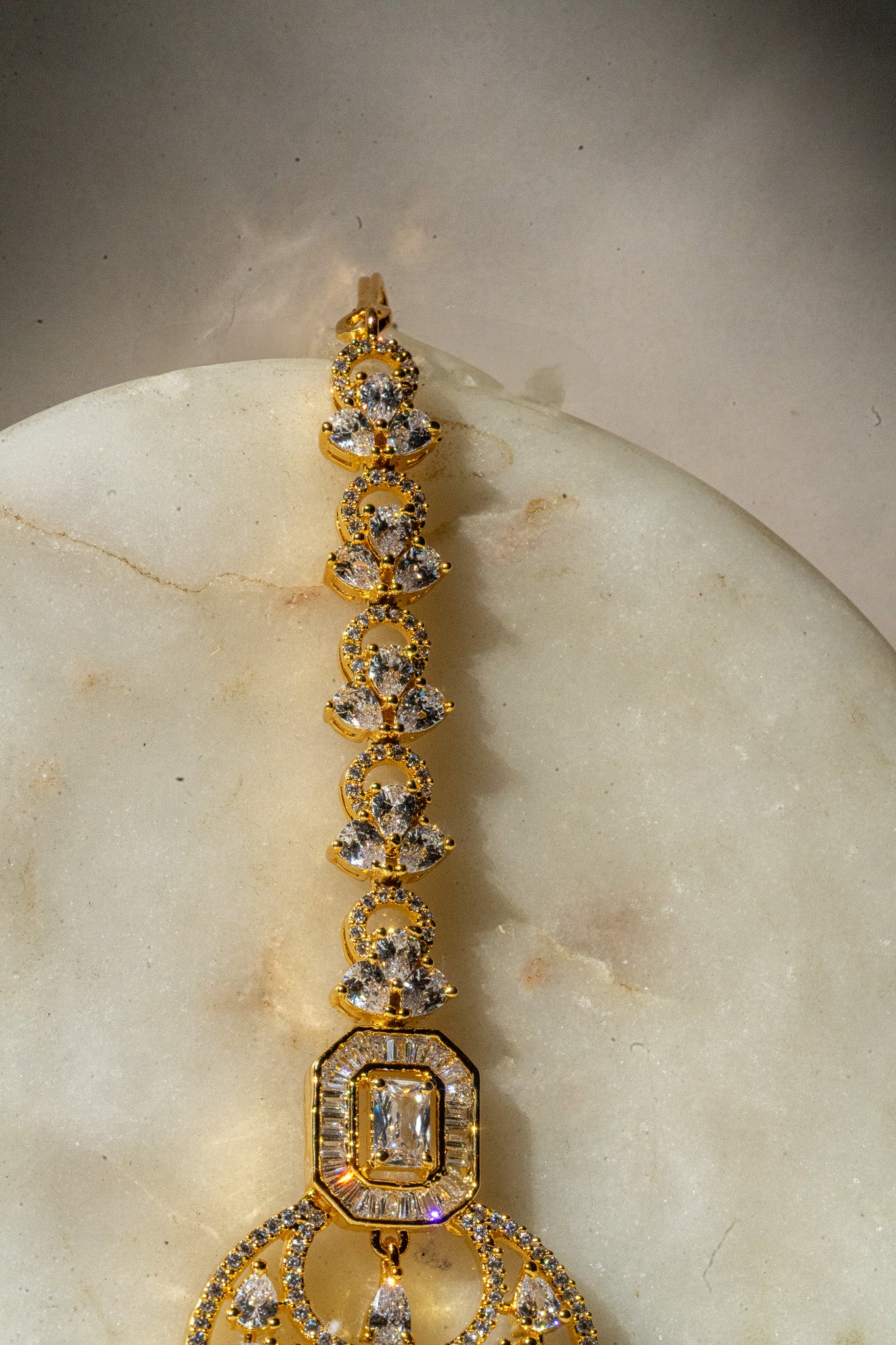 Gold-plated floral maang tikka with American Diamonds in white and pink from Inaury