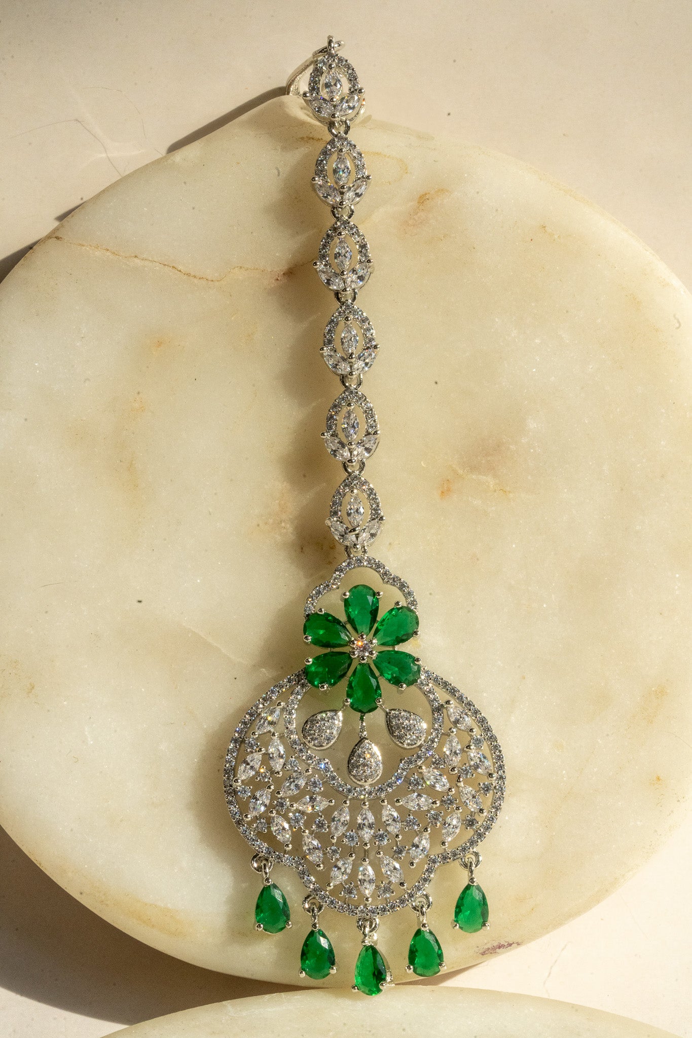 Rhodium-plated floral maang tikka with AD stones in a silver and green from Inaury