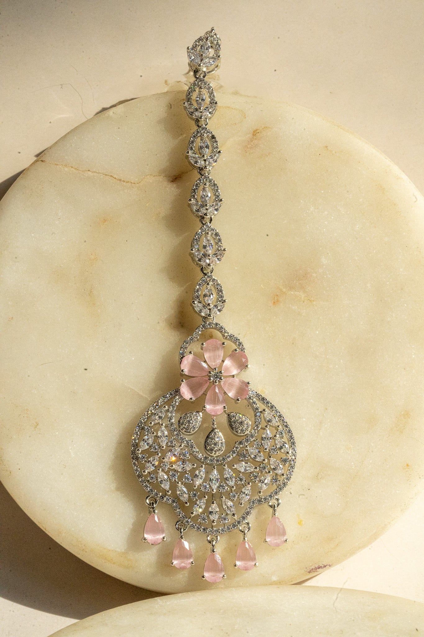 Rhodium-plated floral maang tikka with AD stones in a silver and pink finish from Inaury