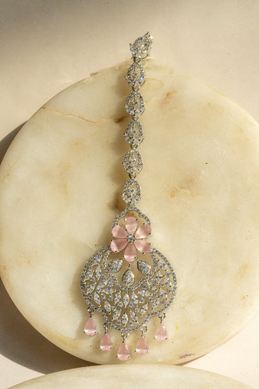 Rhodium-plated floral maang tikka with AD stones in a silver and pink finish from Inaury