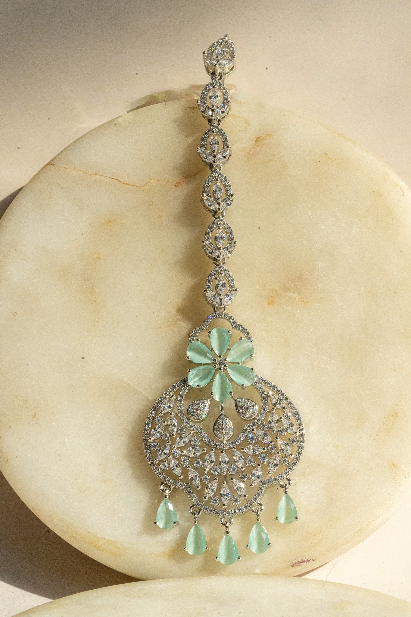 Rhodium-plated floral maang tikka with AD stones in a silver and pink finish from Inaury