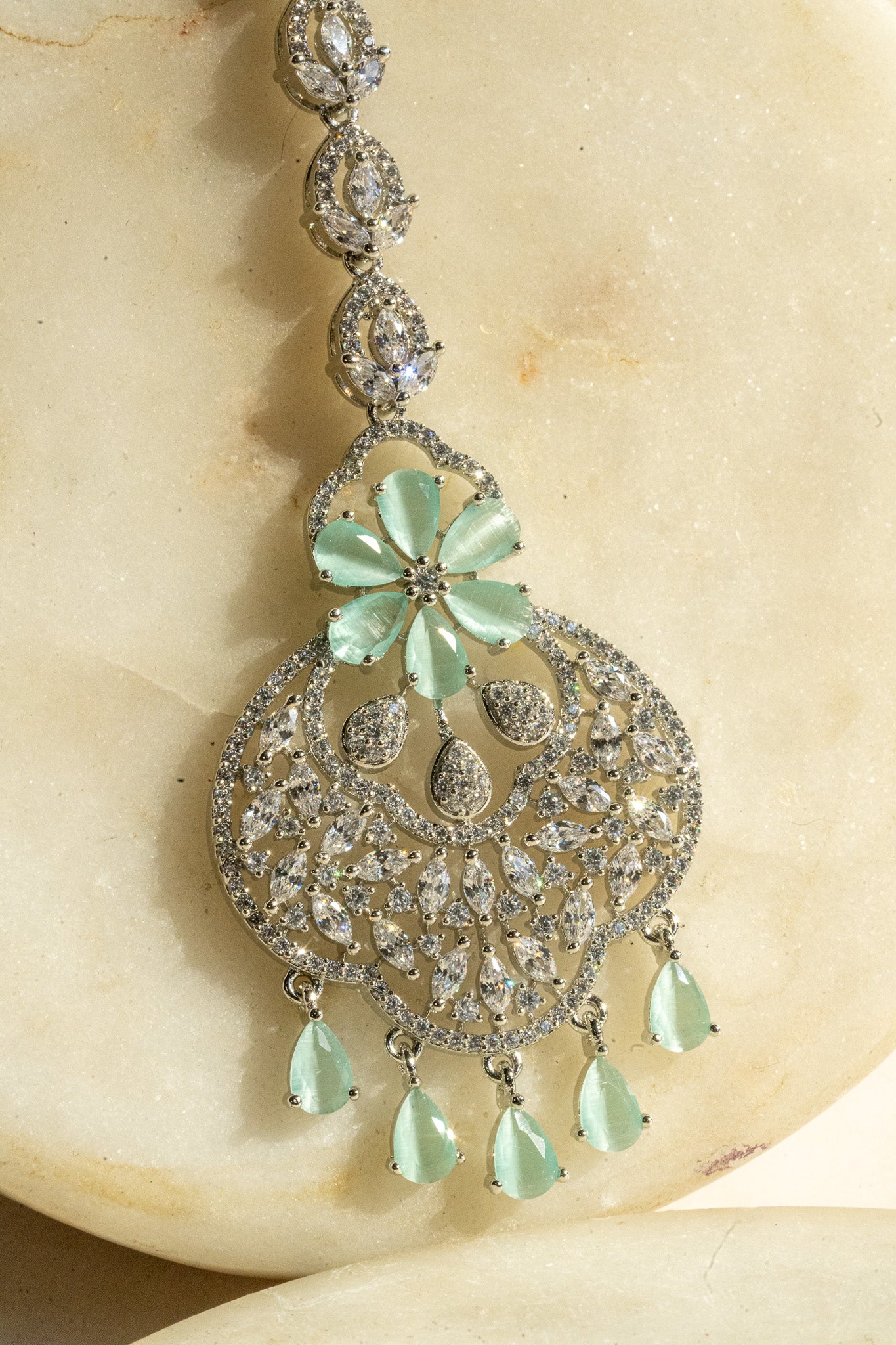 Rhodium-plated floral maang tikka with AD stones in a silver and mint from Inaury