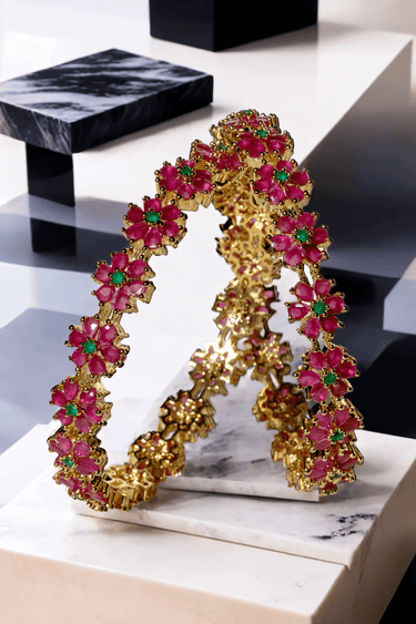 Ruby-accented floral bangles from the Arika gold-plated 7-piece set. Elegant accessory for ethnic and bridal wear collections.