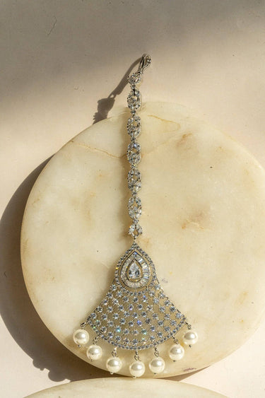 Rhodium-plated maang tikka with white American Diamonds and pearl drop accents from Inaury