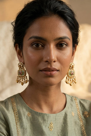 A close up side profile portrait of a model highlighting the intricate seed pearl details and ruby stone work on the Aadhya Kundan earrings.