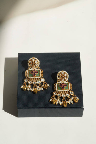 An alternative angled presentation layout showing the foil backed glass polki stones of the Aadhya earrings resting on top of a jewelry box.