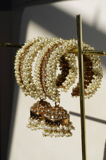 Close-up of the Aliya Jhumka Bangle Bracelet in antique gold with faux pearl beadwork, showing multiple bangles and jhumka charms together.