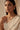 Front-facing portrait of a model wearing the Dilara minimalist gold-plated necklace with clear heart-cut glass Kundan stones and matching geometric cluster stud earrings.