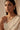 Front-facing portrait of a model wearing the Dilara minimalist gold-plated necklace with clear heart-cut glass Kundan stones and matching geometric cluster stud earrings.