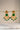 A front e-commerce catalog display showcasing the monochrome emerald green variant of the Kavya gold-plated statement chandbali earrings.
