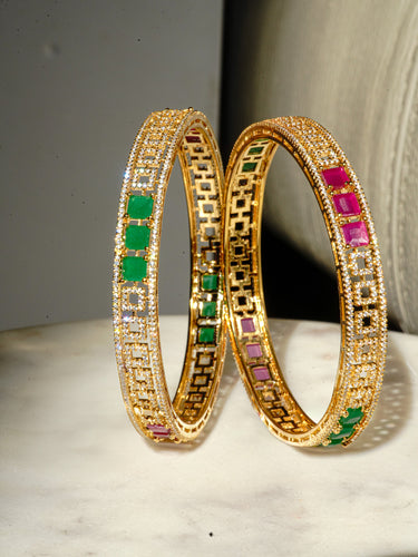 A clean vertical studio product display of the pair of gold plated Kyra traditional festive bangles showcasing the color blocked gemstone layout.
