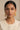 A clean front portrait of a model styling the gold plated Lara handcrafted filigree jhumka earrings paired with an elegant cream embroidered dress.