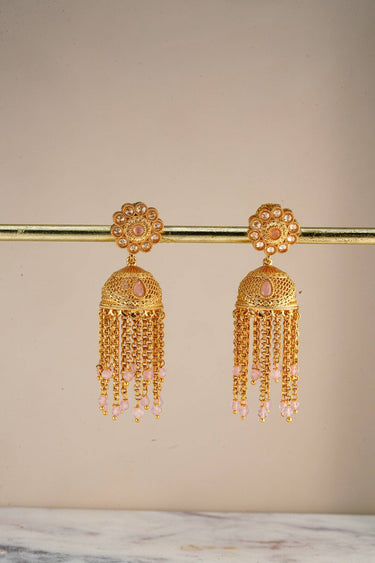 A pristine front studio catalog view of the pair of gold plated Lara handcrafted filigree jhumka earrings hanging symmetrically on a display stand.