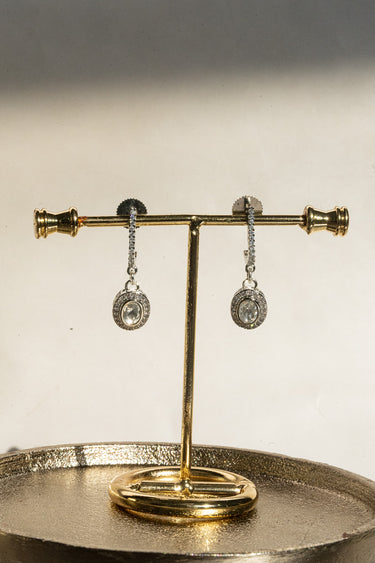 A clear front-facing detail view of the Sania minimalist kundan drop earrings, showcasing the high-shine rhodium finish and the stone-lined vertical setting.