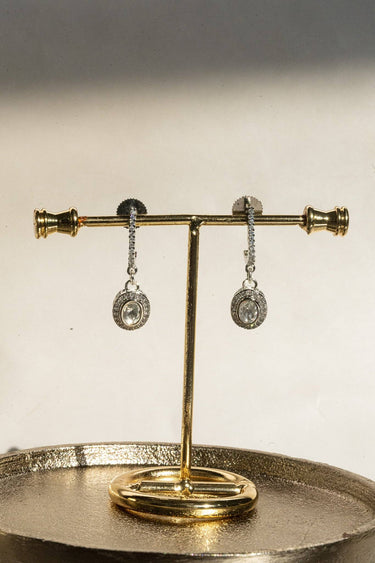 A clear front-facing detail view of the Sania minimalist kundan drop earrings, showcasing the high-shine rhodium finish and the stone-lined vertical setting.