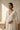 A wide landscape portrait layout of a model wearing the Sania minimalist triple-chain Kundan necklace set with a dark evening dress.