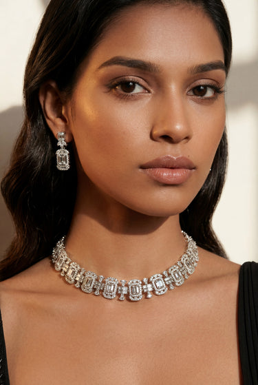 A lifestyle studio portrait of a model wearing the rhodium-plated Shanaya geometric choker set paired with an elegant black saree.