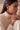 A side profile lifestyle portrait of a model wearing the rhodium plated Sia hoop earrings with pearl bead fringe accents paired with a cream turtleneck sweater.