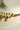 Close-up of the Kundan pearl necklace's gold-plated connector bar joining pearl strands, stones and chain.