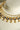 Kundan pearl necklace detail showing reflective round stones, gold-plated bezels and cream pearl drops.