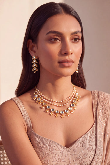 Model wearing a layered Kundan pearl choker necklace with matching gold-plated drop earrings, Yasmin set.