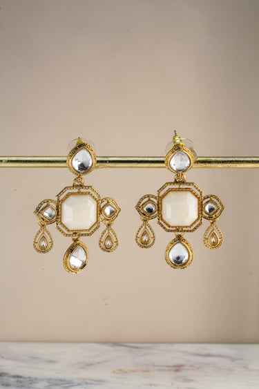 A crisp front studio view of the pair of Zoe mehndi gold drop earrings showcasing the symmetrical layout of crystals on a display bar.