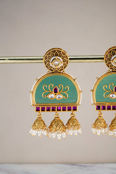 Close-up of Inaury Ananya Meenakari Arch Jhumka Earrings Mint on model — gold filigree stud with enamel arch, kundan lotus motif, and mini jhumka bells