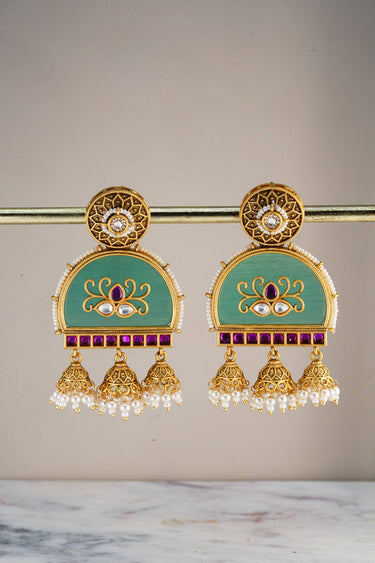 Model wearing Inaury Ananya Meenakari Arch Jhumka Earrings Mint — gold-plated meenakari statement earrings with lotus motif and pearl drops for desi wedding jewelry