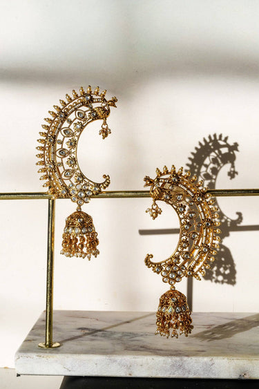 Inaury Maharani Ear Cuffs with Jhumka Pearl White displayed on gold earring stand — handcrafted South Asian bridal ear cuff jewelry with faux pearl accents
