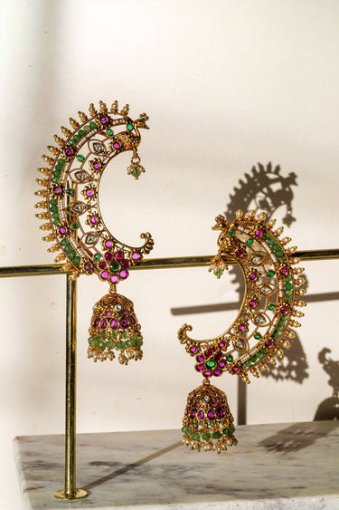 Inaury Maharani Ear Cuffs with Jhumka Ruby Emerald displayed on gold earring stand — luxury desi ear cuff jewelry with ruby, emerald, and jade bead details