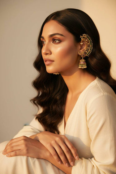 Inaury Maharani Ear Cuffs with Jhumka in Ruby Emerald — gold-plated crescent ear cuff with ruby-pink and emerald stones styled with cream silk outfit