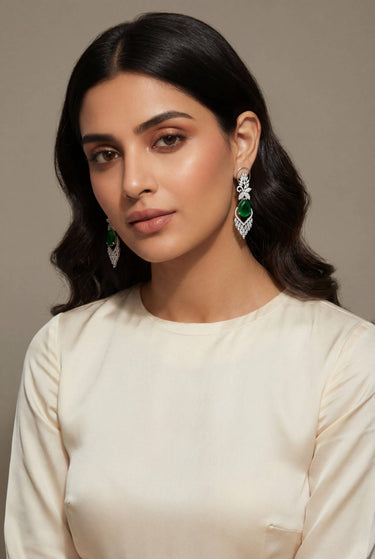 Inaury Nimisha AD Drop Earrings Emerald Green on model — rhodium-plated statement drop earrings with green teardrop stone for Eid and formal occasions