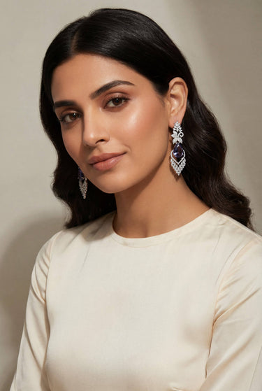 Nimisha AD Drop Earrings in Purple on model — rhodium-plated chandelier earrings with amethyst teardrop stone and AD marquise cascade styled with cream top