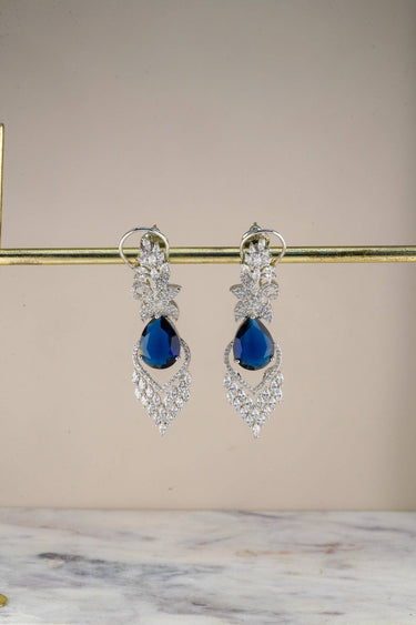 Inaury Nimisha AD Drop Earrings in Sapphire Blue — rhodium-plated chandelier earrings with deep blue teardrop stone and brilliant AD stone framework on earring stand
