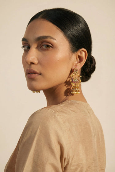Inaury Saaira Kundan Chandbali Jhumka Earrings on model — gold-plated three-tier earrings with lotus motif and pearl drops styled with beige silk top