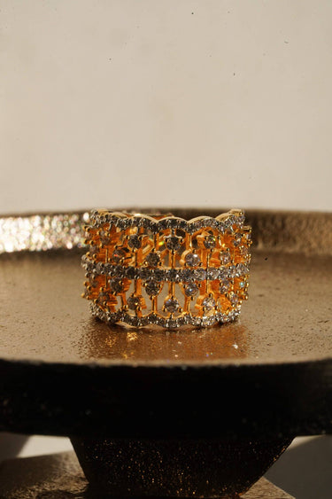 Talia gold plated AD lattice band ring front view on gold tray showing open work grid and prong set stones Inaury