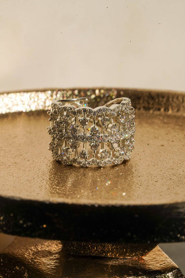 Talia rhodium plated AD lattice band ring front view on gold tray showing wide band with individually set AD stones Inaury